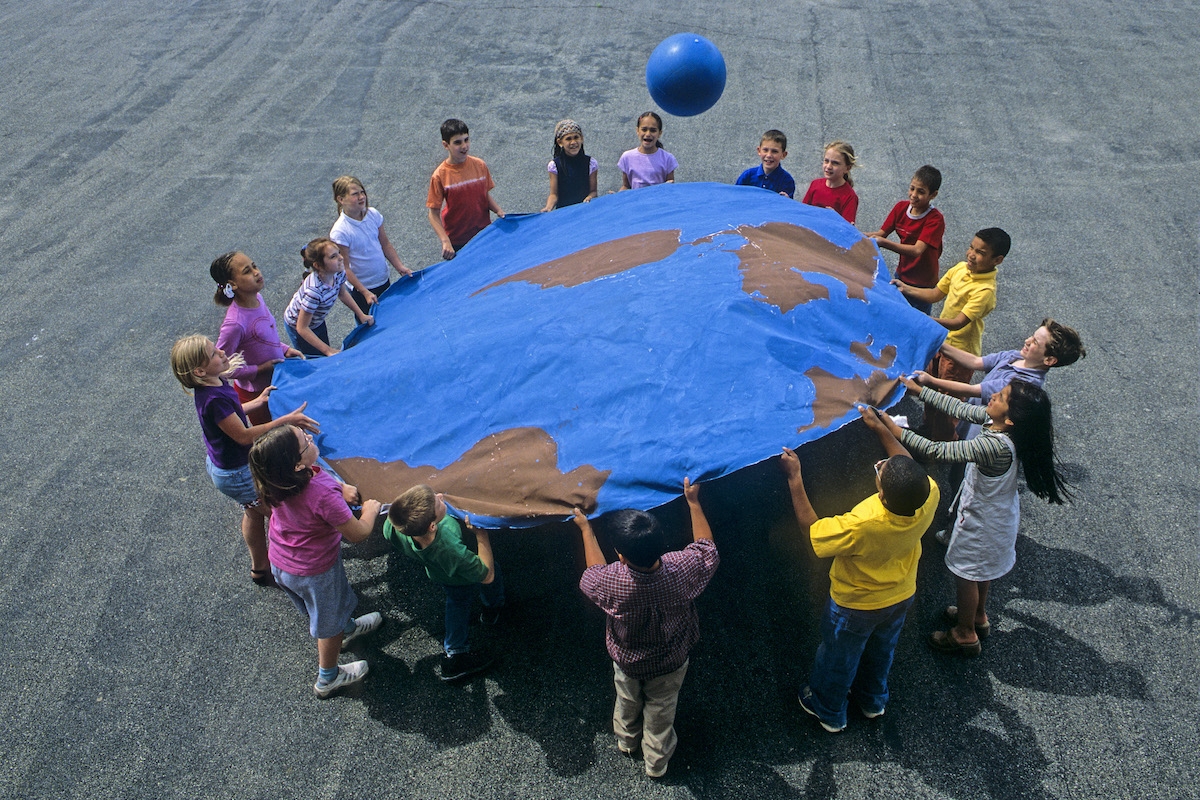 Grade 3 students collaborate as they play "Earth Ball" game  with big circle